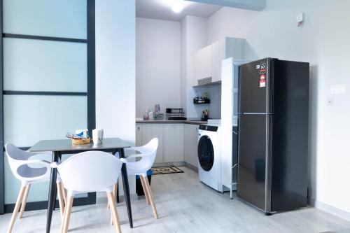 a kitchen with a table and a refrigerator at Jesselton Quay T2 by SNUG SPACE in Kota Kinabalu