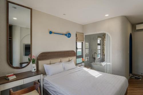 a bedroom with a white bed and a mirror at Nhà A Trí in Bình Tú
