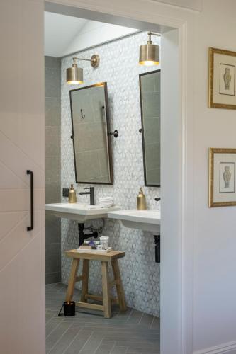 a bathroom with two sinks and two mirrors at The Strand at The Vineyard McLaren Vale - King BR, Comp Minibar, Breakfast Prov, Fireplace in Blewitts Springs