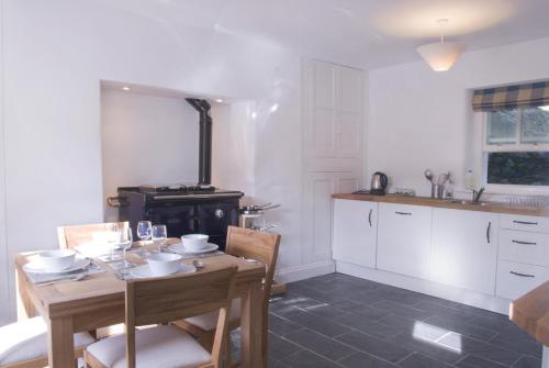 a kitchen with a table and a stove at Bronfelin & Troed-y-Rhiw Holiday Cottage in Llanwrtyd Wells
