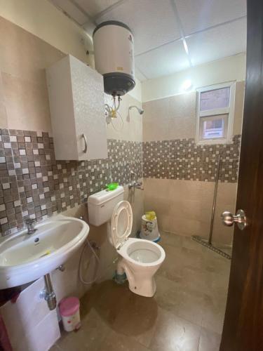 a bathroom with a toilet and a sink at Gorza Apartment in Karnal
