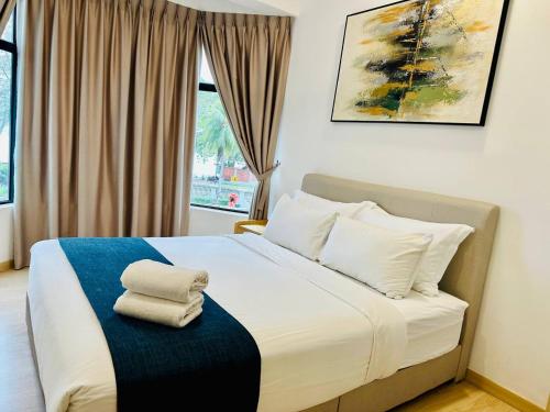 a bedroom with a bed with two towels on it at Mutiara Melaka Beach Resort by Glex in Tangga Batu