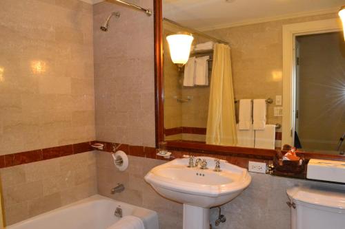 La salle de bains est pourvue d'un lavabo, de toilettes et d'une baignoire. dans l'établissement The Wall Street Inn, à New York