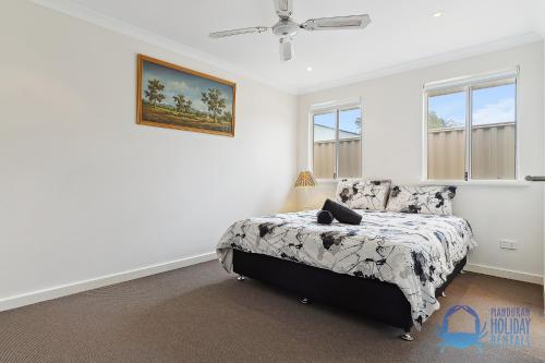 a bedroom with a bed and a painting on the wall at Relax at Falcon By The Bay in Mandurah