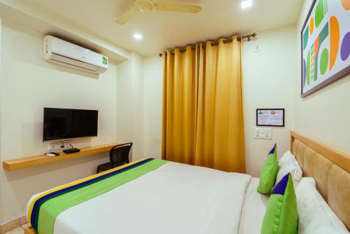 a bedroom with a bed and a television in it at Treebo Elmas Grand in Bengaluru