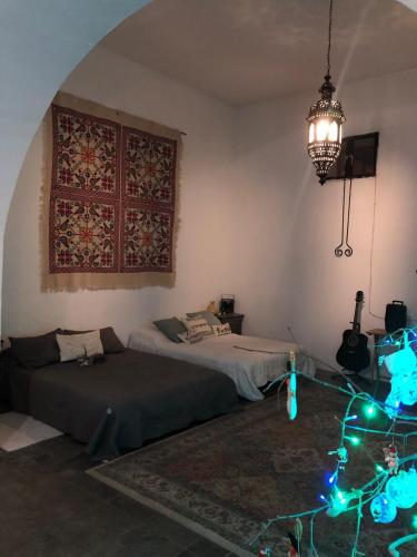 a bedroom with two beds and a chandelier and christmas lights at Casa Historica Colonial in Álamos