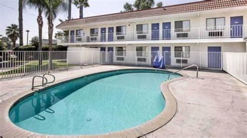 a large swimming pool in front of a building at Motel 6 Lake Elsinore, CA in Lake Elsinore