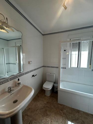 a bathroom with a sink and a toilet and a mirror at chalet adosado La morena cerca del caminito del rey in Ardales