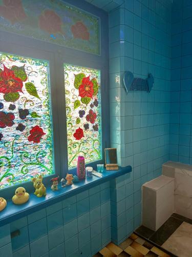 a bathroom with two windows with flowers on them at Napoli Nataxtari hotel,pool,bar,kamping in Natakhtari