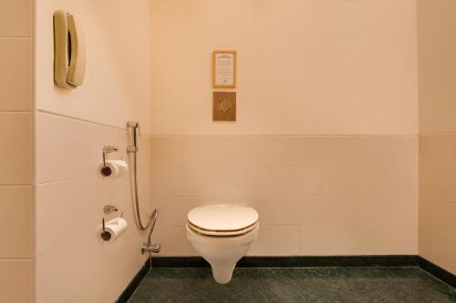a bathroom with a toilet and a phone at Red Fox by Lemon Tree Hotels, Hyderabad in Hyderabad