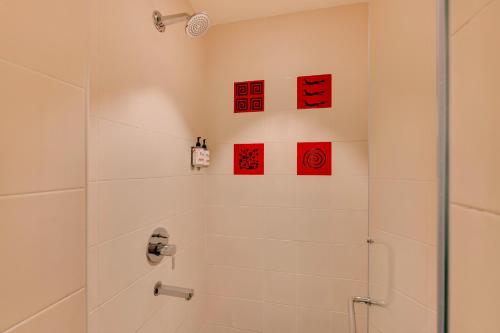 a bathroom with a shower with red cards on the wall at Red Fox by Lemon Tree Hotels, Hyderabad in Hyderabad