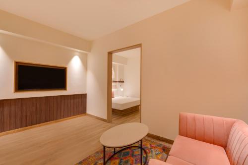 a living room with a pink couch and a mirror at Red Fox by Lemon Tree Hotels, Hyderabad in Hyderabad
