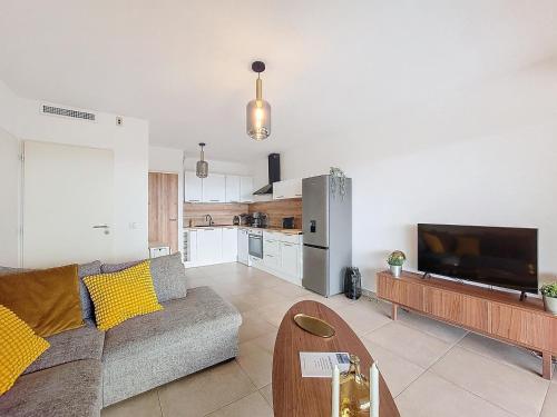 un salon avec un canapé, une télévision et une table dans l'établissement Appart, vue mer exceptionnelle à sanary, à pied 10mn criques et plage, à Sanary-sur-Mer