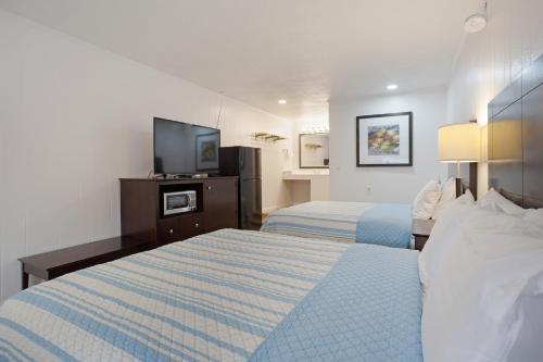 a hotel room with two beds and a flat screen tv at Highport INN in Pottsboro