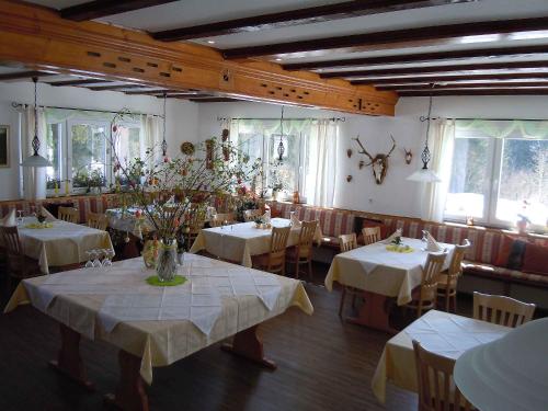 uma sala de jantar com mesas e cadeiras com toalha de mesa branca em Klosterweiherhof em Dachsberg im Schwarzwald