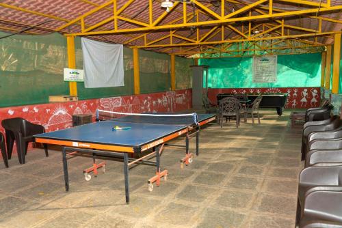 a ping pong table in a room with chairs at Wild Camp- The Nature Resort in Khodāla