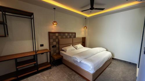 a bedroom with a bed and a ceiling fan at Yes Hotel By The Ganges in Rishīkesh