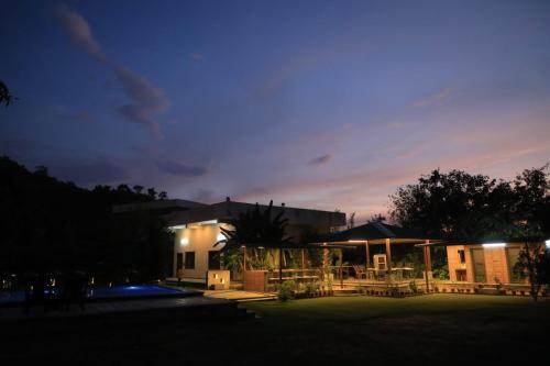 a house at night with the lights on at Ashish Farm House in Amer