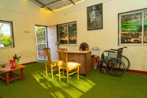 a room with chairs and a desk and a wheelchair at Wild Camp- The Nature Resort in Khodāla