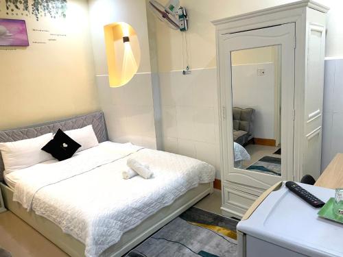 a small bedroom with a bed and a mirror at Khách sạn Sinh Hiền in Liên Trì (4)