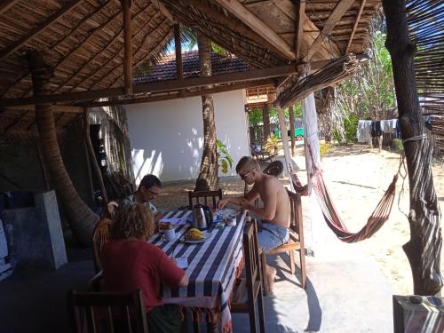 a group of people sitting at a table on the beach at Kitelife Resort in Kalpitiya