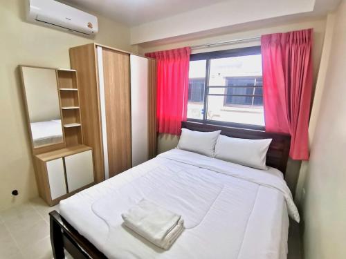 a bedroom with a large white bed with a window at Kata beach Townhouse BL2 in Kata Beach