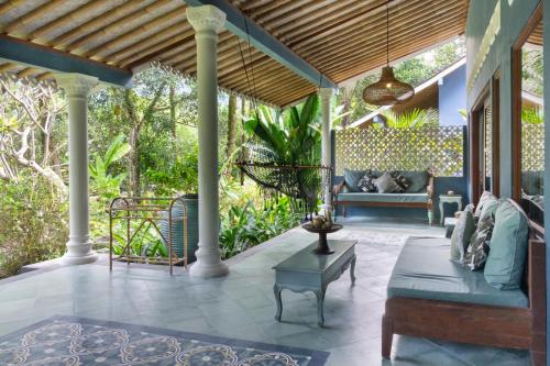 an outdoor patio with a couch and a table at Darmada Eco Resort in Sidemen