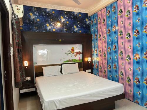 een slaapkamer met een bed in een kamer met een muur bij Indore Home stay in Indore