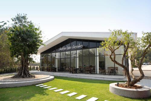 een gebouw met twee bomen ervoor bij Daoneua Riverside Resort in Muang Fuang