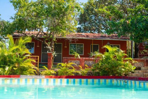 a house with a swimming pool in front of a house at Wild Camp- The Nature Resort in Khodāla