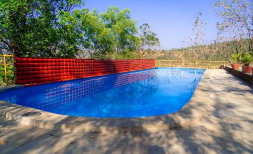 a swimming pool with a red and blue at Wild Camp- The Nature Resort in Khodāla