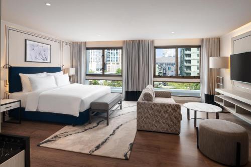 a bedroom with a bed and a living room at Radisson Hotel Chateau de Bangkok in Bangkok