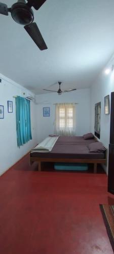 a bedroom with a bed and a ceiling fan at Casa Shanti in Kannur