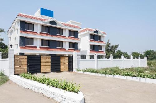a large white building with a white fence at Casa Fedora Holiday Home in Lonavala