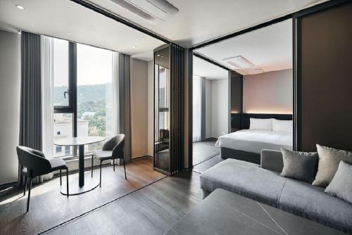 a hotel room with a bed and a couch and a table at HOMES Stay MyeongDong in Seoul