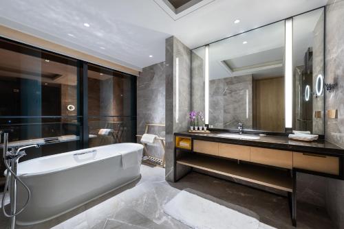 a bathroom with a tub and a sink at Grand Mercure Shanghai Lingang in Shanghai