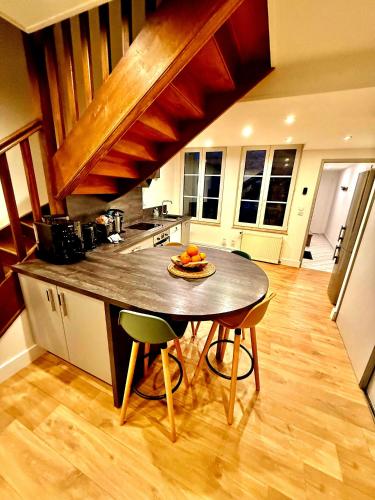 une cuisine avec une table avec un bol de fruits dessus dans l'établissement Le Renaissance Appartement au cœur de Langres, à Langres