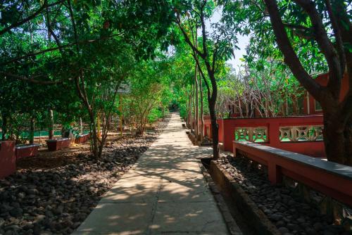 a path in a park with a red fence and trees at Wild Camp- The Nature Resort in Khodāla
