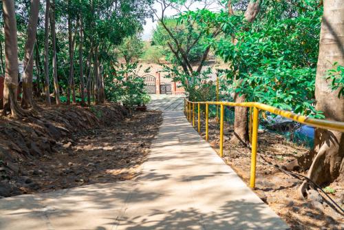 a sidewalk with a yellow railing next to a road at Wild Camp- The Nature Resort in Khodāla