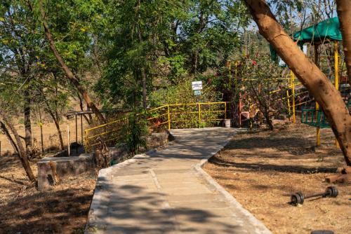 a path in a park with a yellow fence at Wild Camp- The Nature Resort in Khodāla