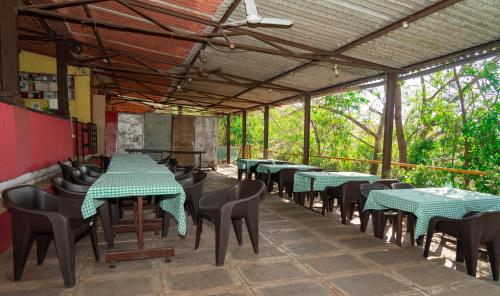 an empty restaurant with green tables and chairs at Wild Camp- The Nature Resort in Khodāla