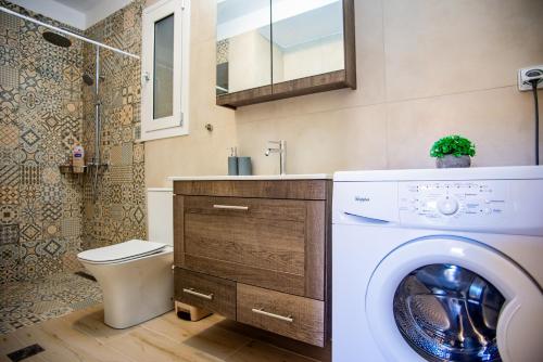 a bathroom with a washing machine and a toilet at Casa Giardino in Argostoli