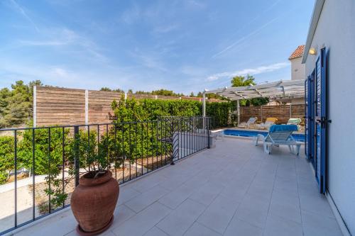 un patio avec un vase sur un balcon dans l'établissement Villa Milna Bay, heated pool, 8 persons, à Milna