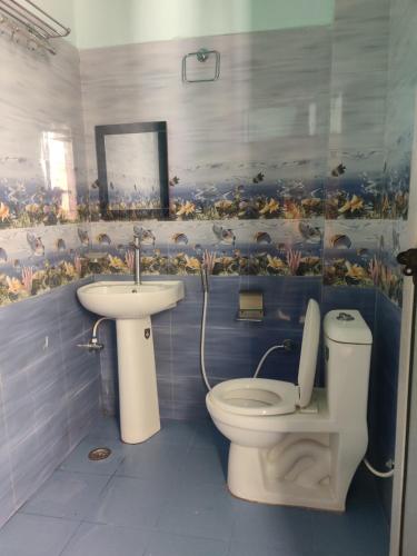 a bathroom with a toilet and a sink at KC Hotel & Restaurant in Rudraprayāg