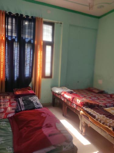 a room with two beds and a window at KC Hotel & Restaurant in Rudraprayāg