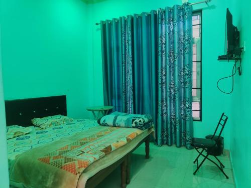 a bedroom with a bed and blue walls and curtains at KC Hotel & Restaurant in Rudraprayāg