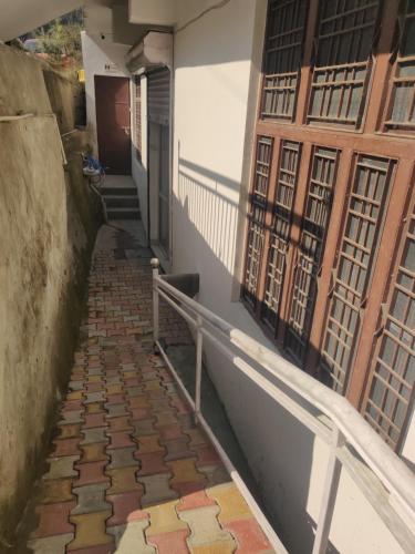 a walkway leading up to a building with a door at KC Hotel & Restaurant in Rudraprayāg
