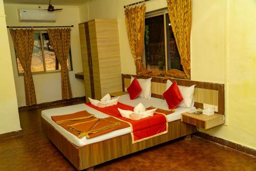 a bedroom with a bed with red and white pillows at Wild Camp- The Nature Resort in Khodāla