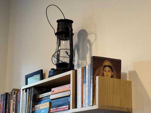 a lamp on top of a book shelf with books at P and B's Home in San-k'un-shen