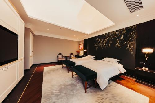 a bedroom with two beds and a tv at 隐居伴山黄鹤楼昙华林店 in Wuhan